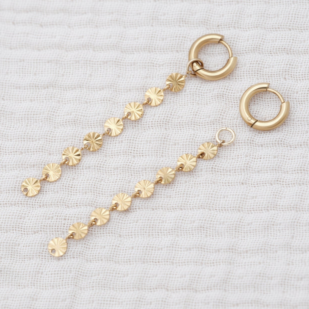 Solar inspired earrings featuring sleek 10mm hoops and a removable 5cm dangly sun charm for added style.