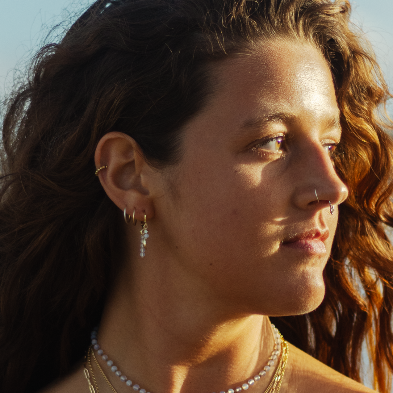 waterproof tarnish free jewellery model showcasing ocean-inspired jewelry in a sunlit outdoor setting.