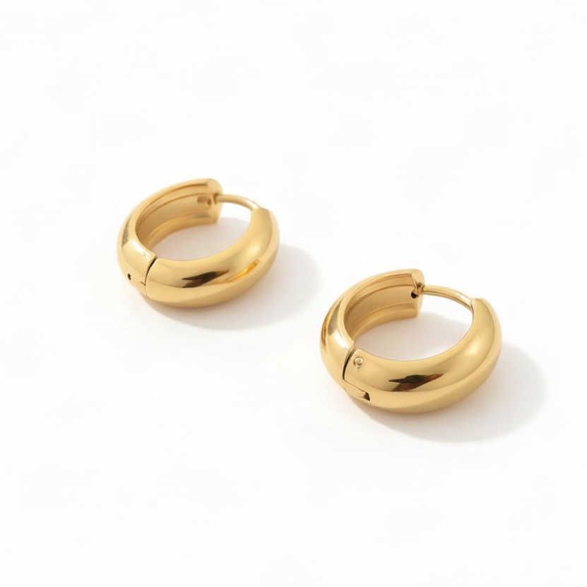 A pair of polished gold huggie hoop earrings on a clean white background.