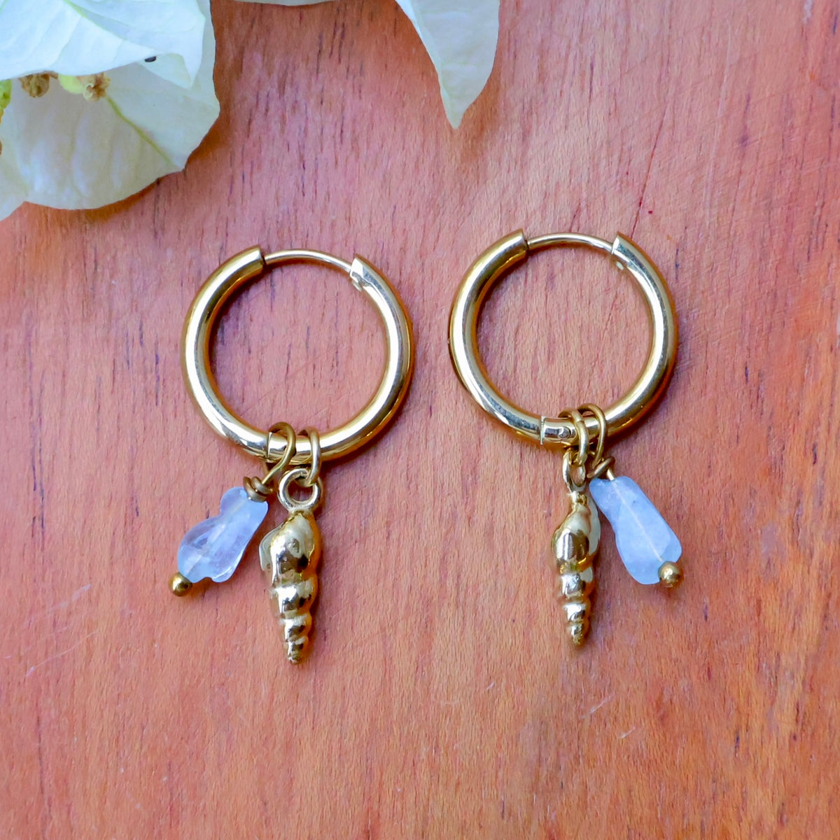 Aquamarine shell earrings featuring removable charms and a screw shell design, perfect for beach-inspired looks.