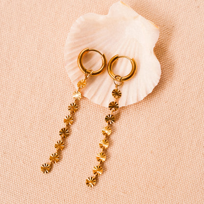 Solar inspired earrings featuring gold hoops with removable sun charms for versatile styling.