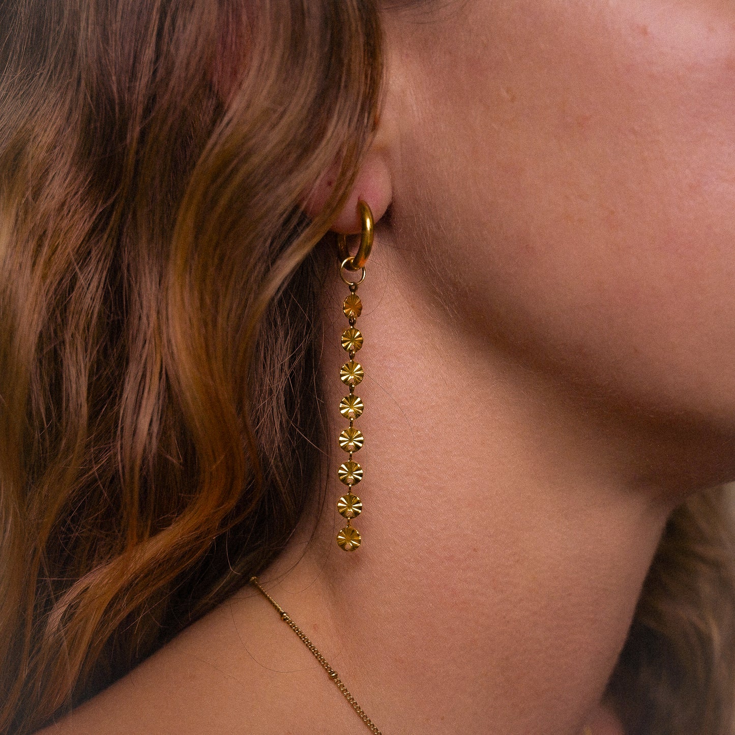 Solar inspired earrings featuring 10mm hoops and removable dangly sun charm for versatile styling.