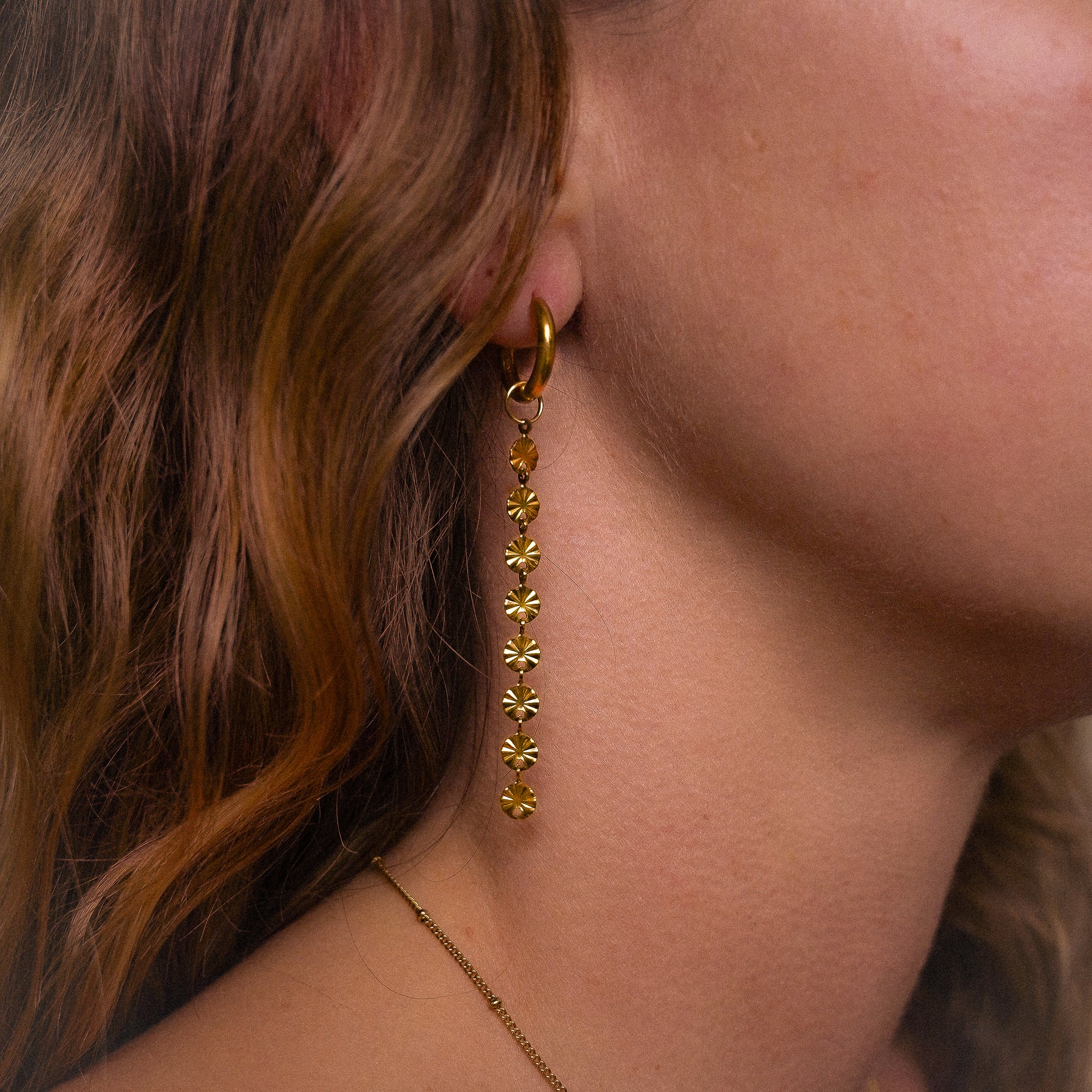 Solar inspired earrings featuring 10mm hoops and removable dangly sun charm for versatile styling.