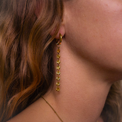 Solar inspired earrings featuring 10mm hoops and removable dangly sun charm for versatile styling.