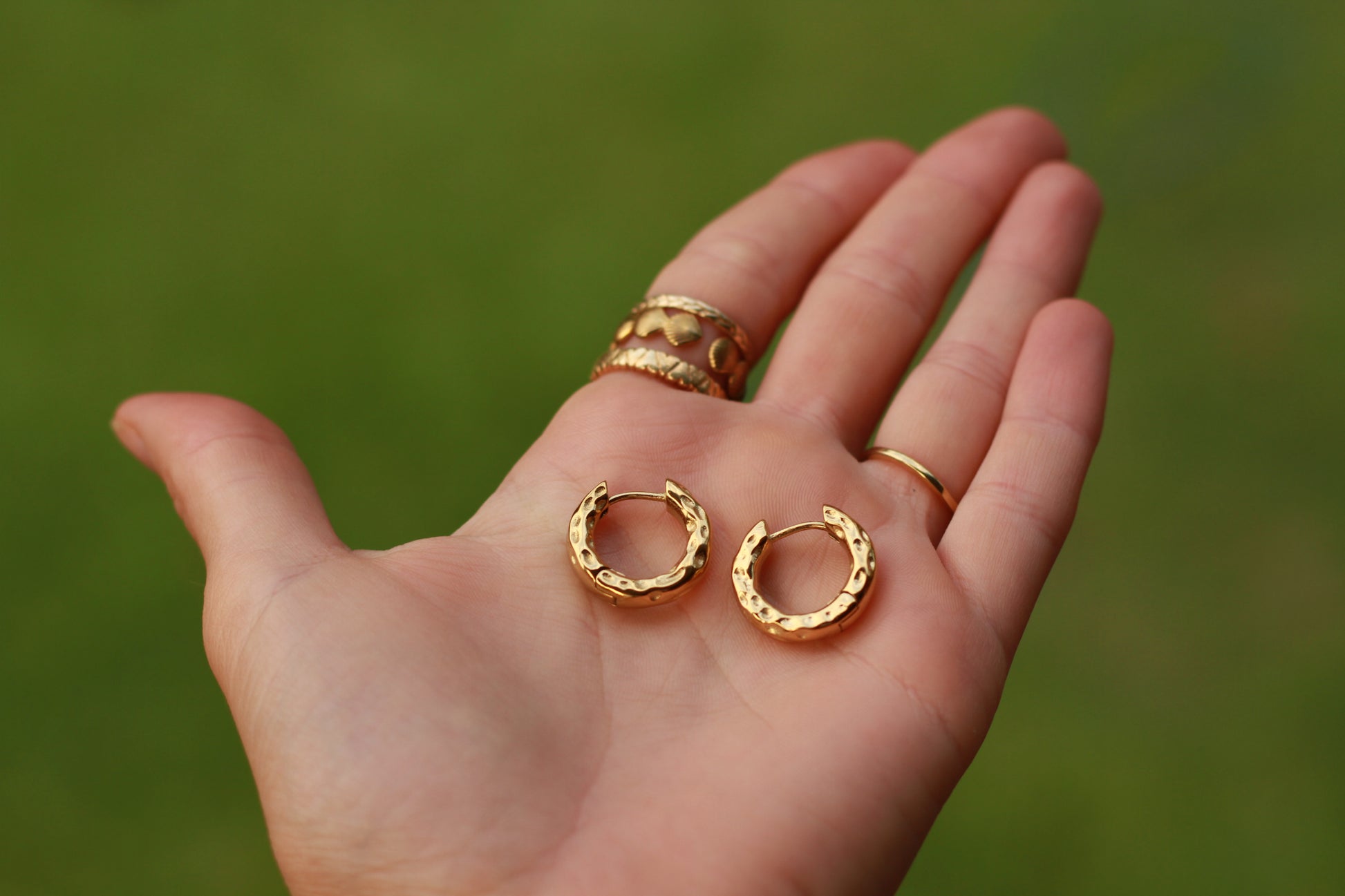Hand holding hammered earrings