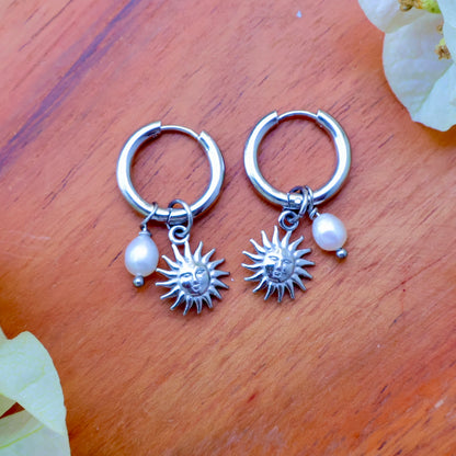 Removable charm earrings featuring a sun and pearl charm on silver hoops for versatile style.