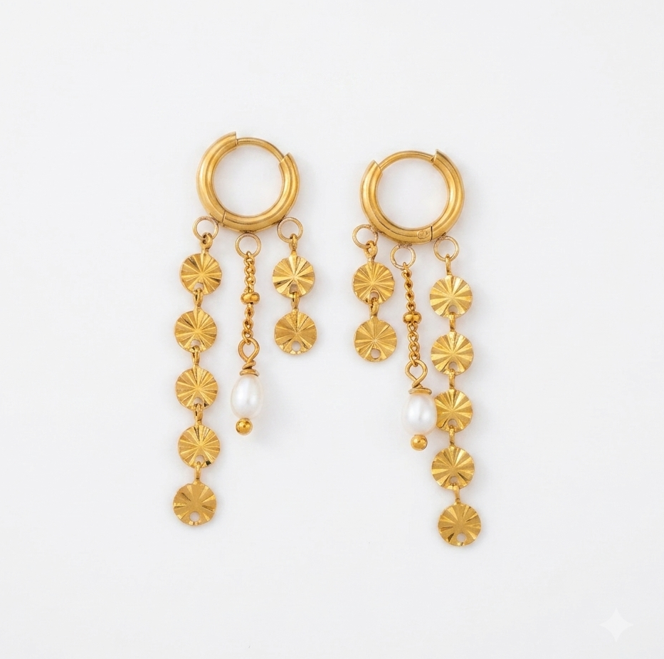 A pair of gold dangle earrings with hoop tops, hanging flower-shaped charms, and small white pearl accents, displayed on a clean white background.