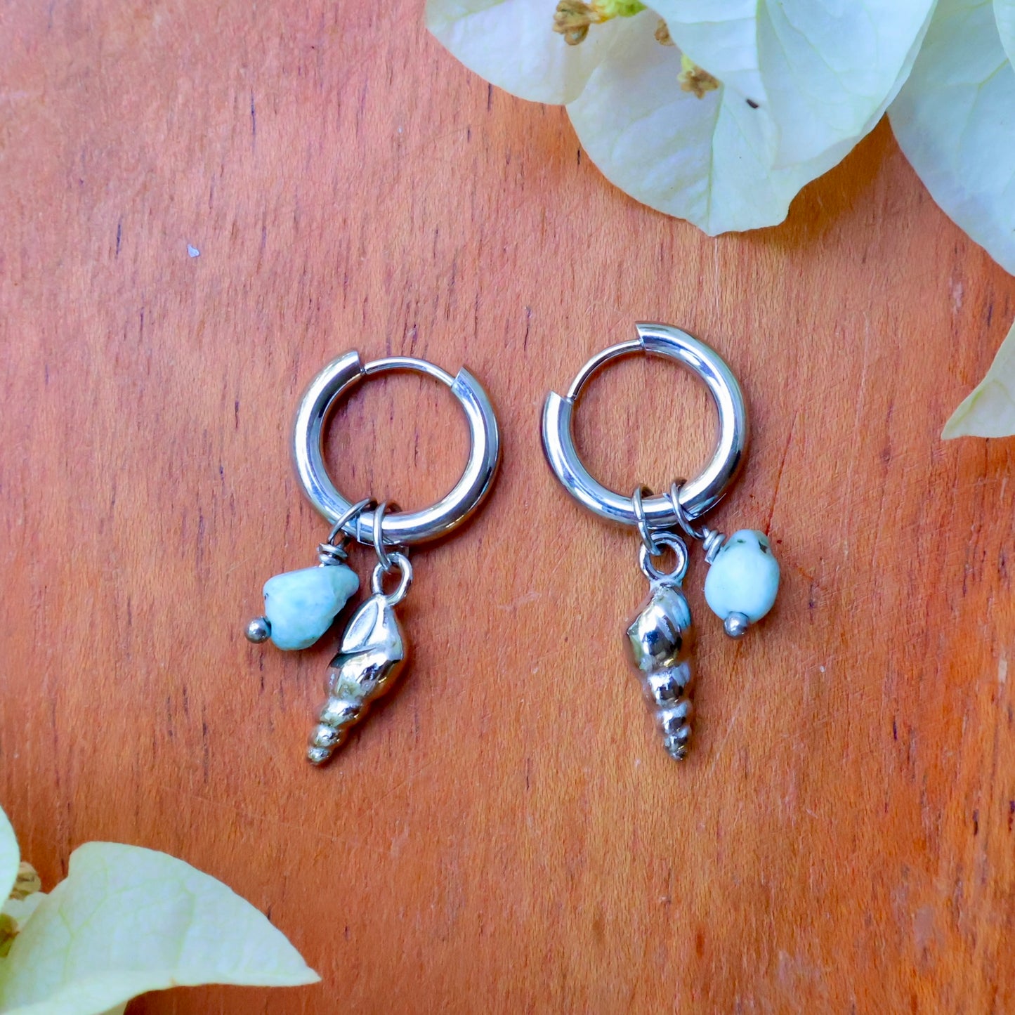 Worm Snail shell earrings with aquamarine charms on silver hoops, perfect for beach-inspired outfits and everyday wear.