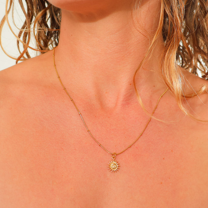 small gold sun necklace
